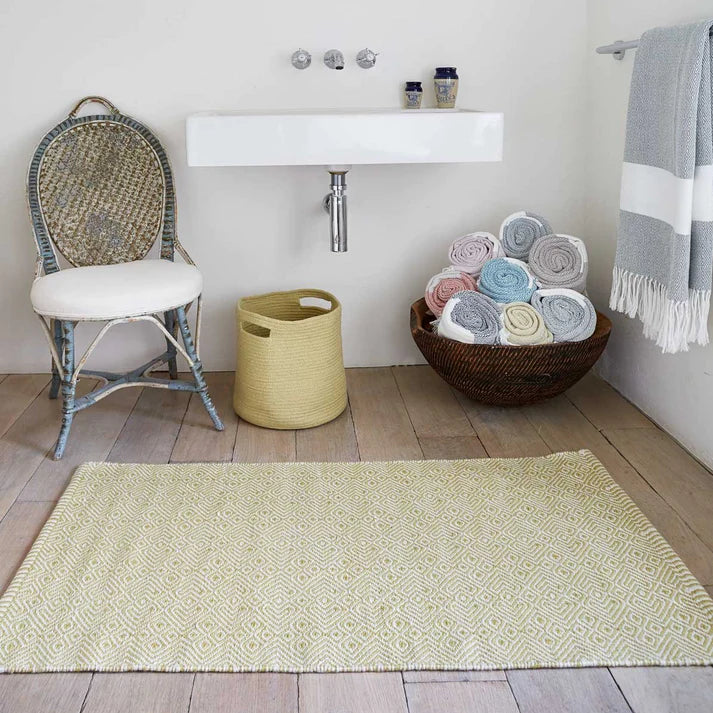 delicate yellow green rug placed in a bathroom with stylised accessories