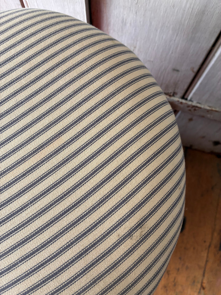 Close-up of the blue stripe ticking-covered lid of a quirky red enamel stool from Source for the Goose, Devon.