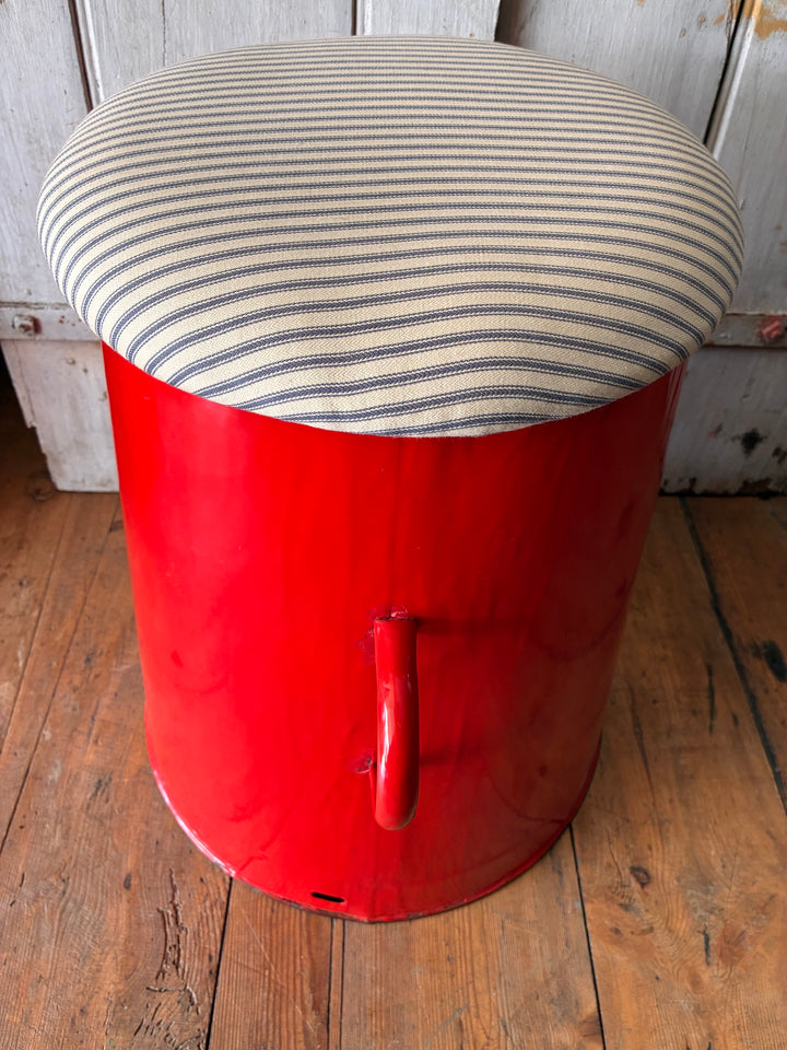 Quirky red enamel stool with blue stripe ticking lid, perfect for storage and stylish hallway decor.