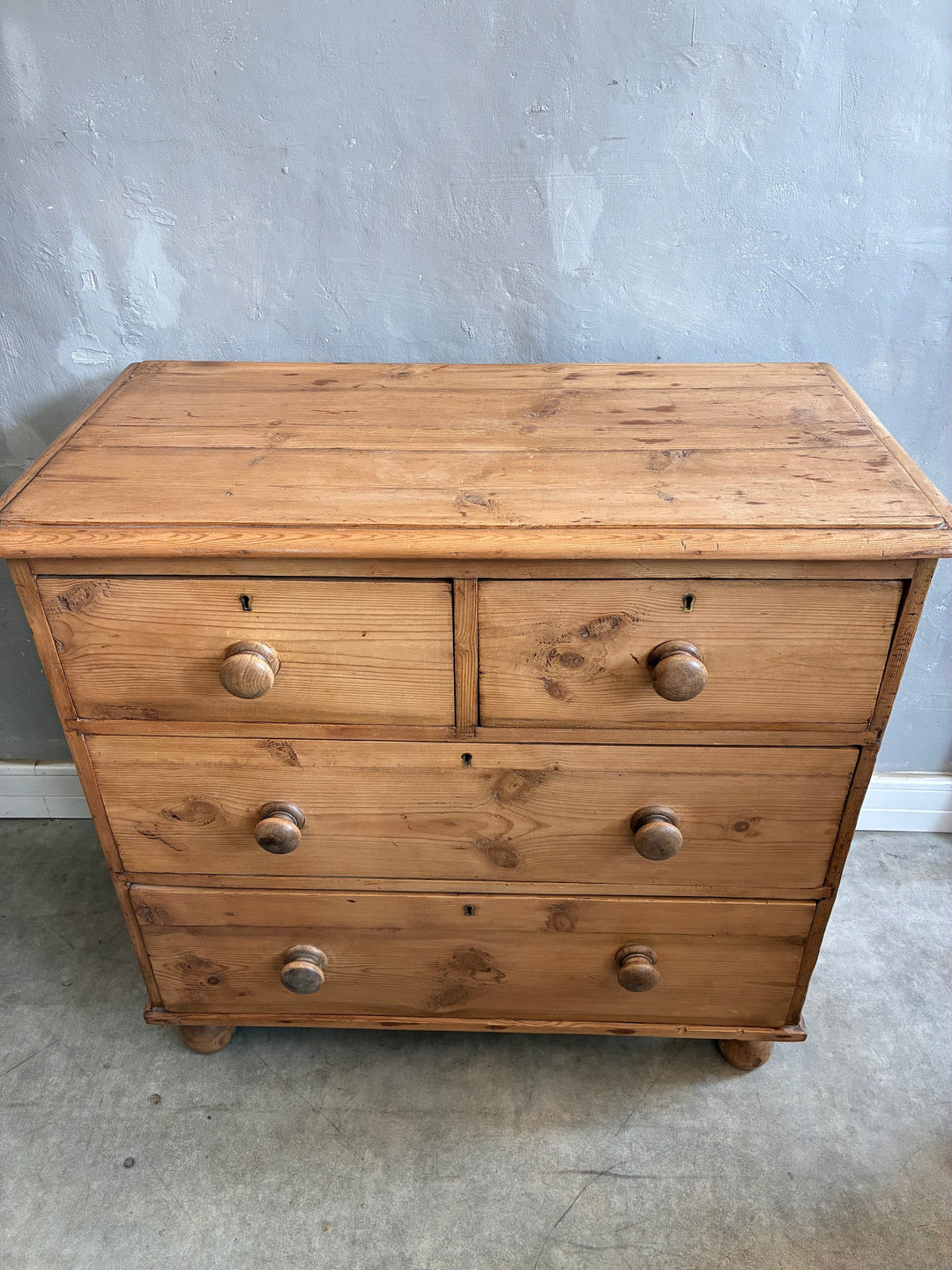 Rustic antique pine chest of drawers with two over two design, original knobs, and turned feet from Source for the Goose, Devon.