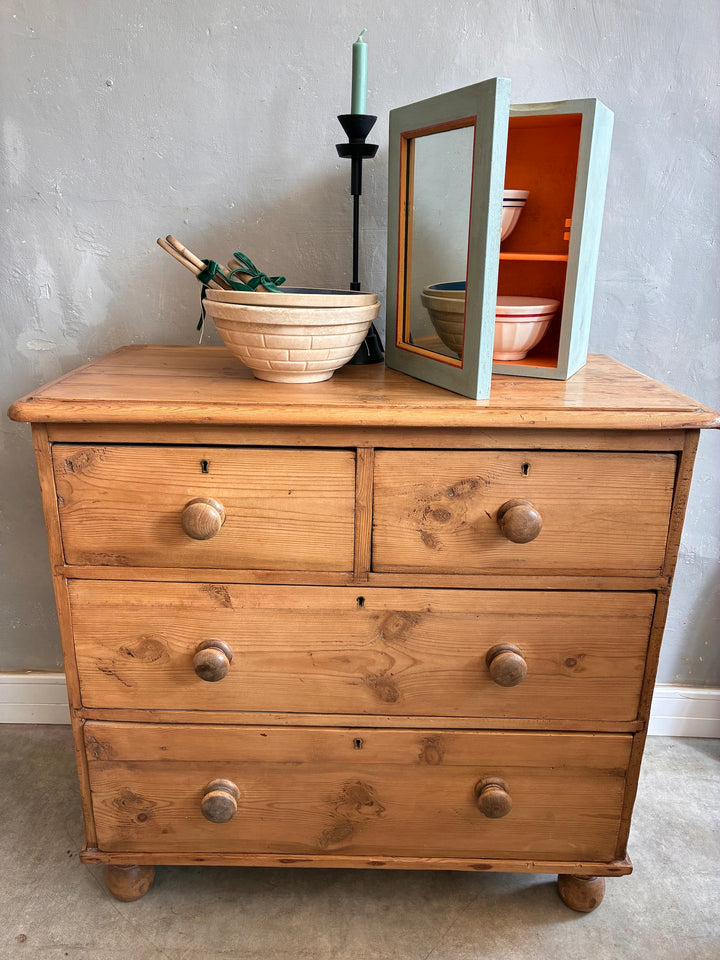 Rustic antique pine chest of drawers with original knobs, vintage charm, styled with decorative items.