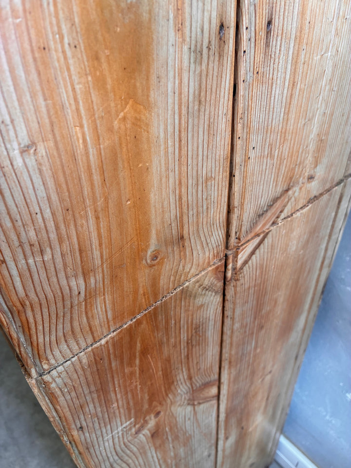 Close-up of the textured wood surface of the Tall Rustic Pine Housekeepers Cupboard.