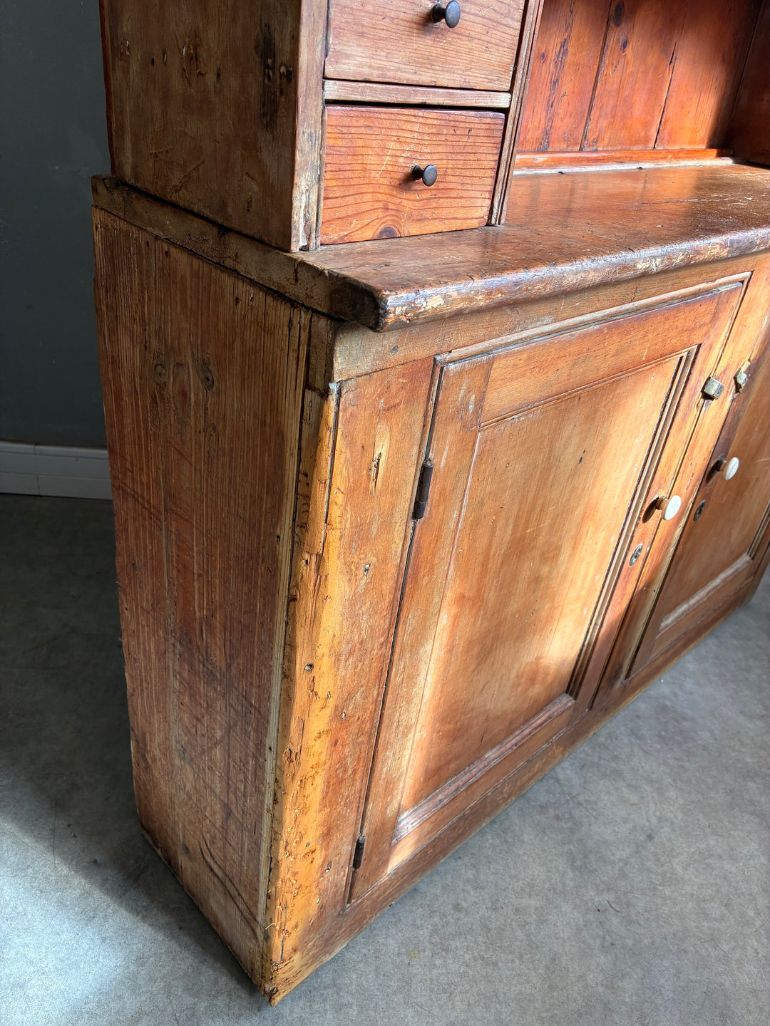 Rustic Antique Pine Dresser showcasing aged wood texture and two-door cupboard, perfect for country kitchen decor.