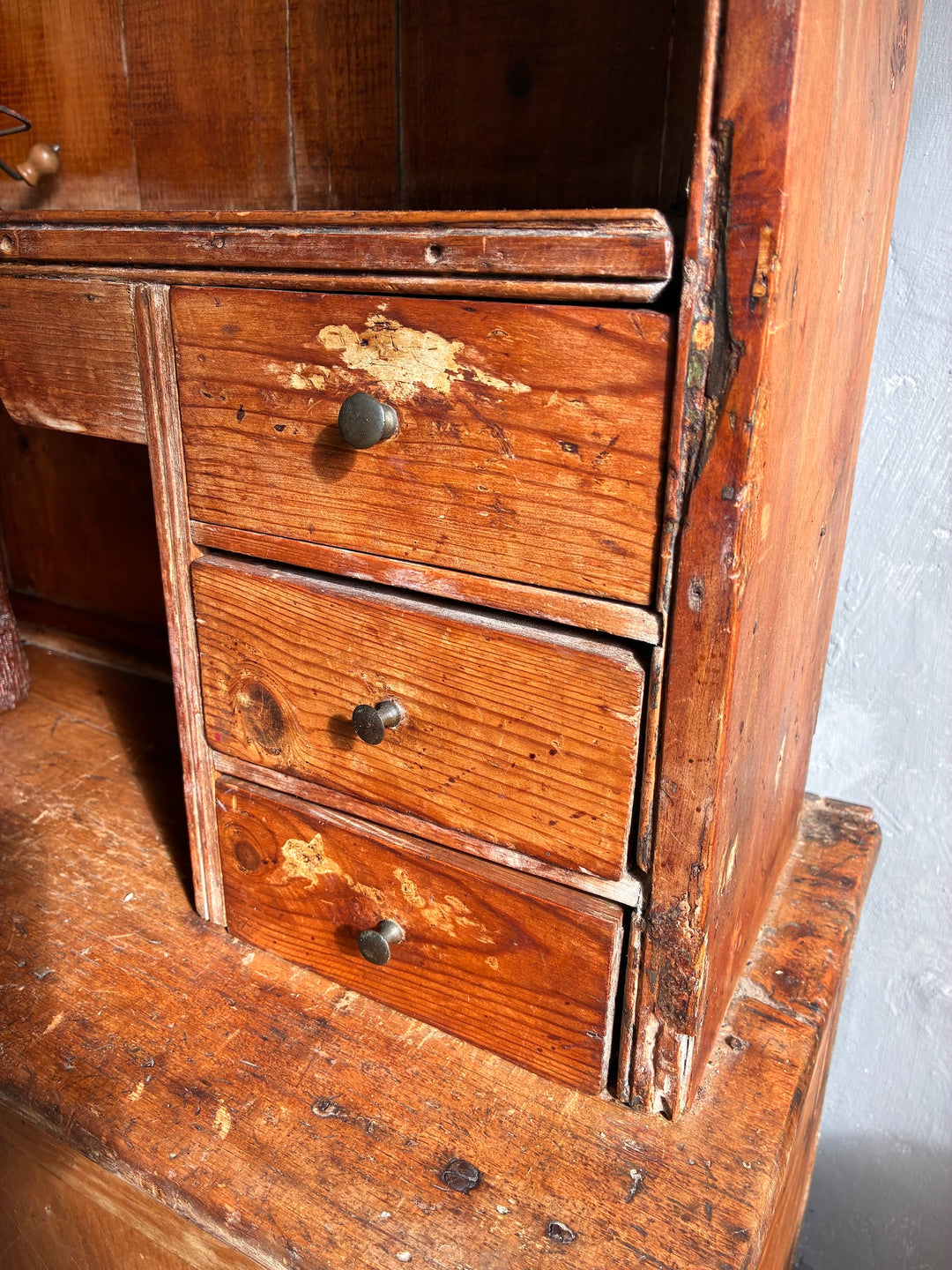 Close-up of three drawers on a Rustic Antique Pine Dresser, showcasing its aged wood and vintage hardware.
