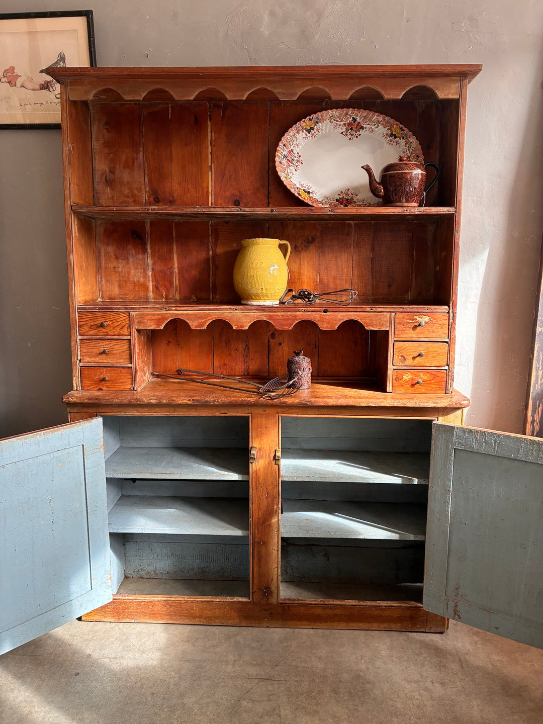 Rustic Antique Pine Dresser showcasing a wooden design with a plate rack and storage cupboards. Source for the Goose Devon.