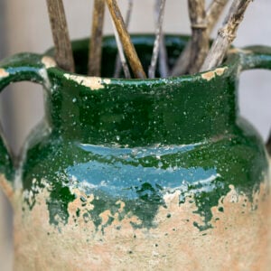 Rustic vase with green glaze and distressed finish, featuring twigs, from Source for the Goose, Devon.
