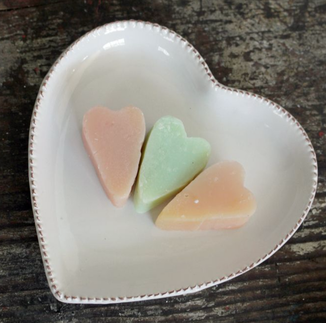 delicately heart shaped white ceramic bowl with small soaps