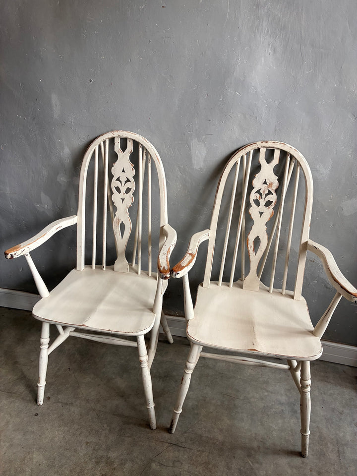 Set of Four Painted Wheelback Carver Chairs featuring a warm white finish and vintage design details.