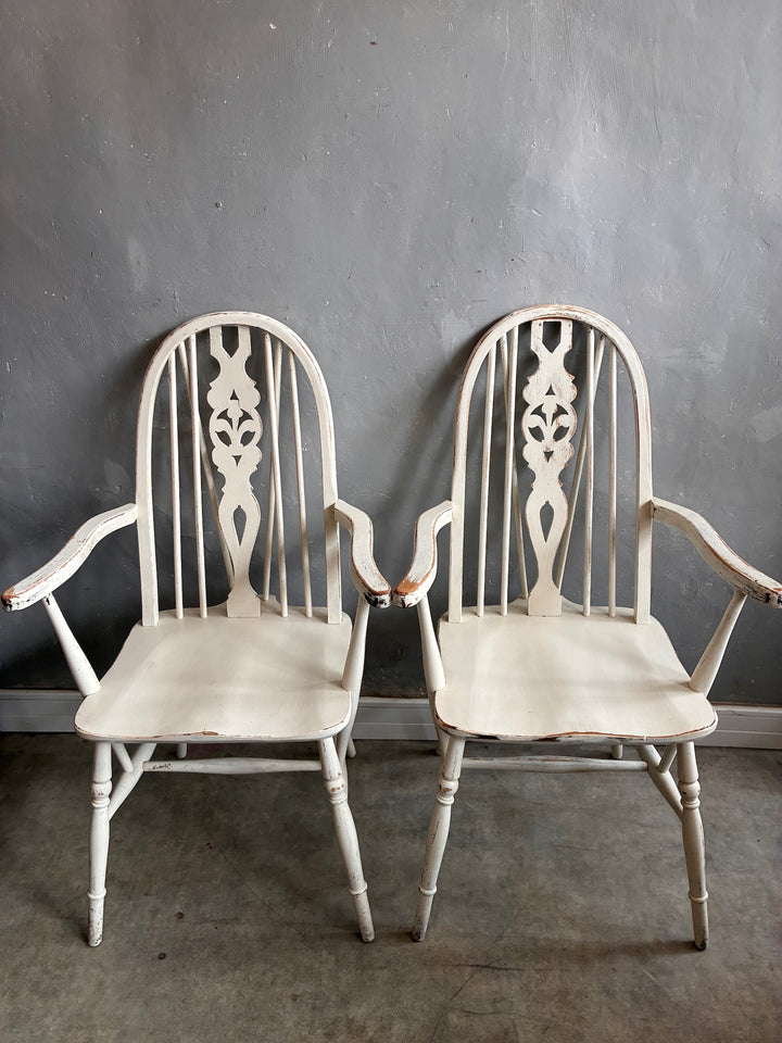 Set of Four Painted Wheelback Carver Chairs featuring a carved wheel motif and elegant bow-shaped backs.