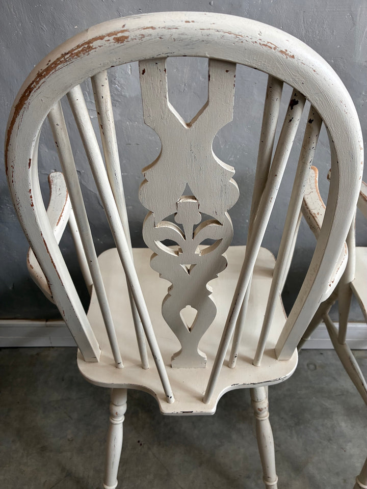 Set of Four Painted Wheelback Carver Chairs featuring a distinctive carved wheel motif in warm white finish.