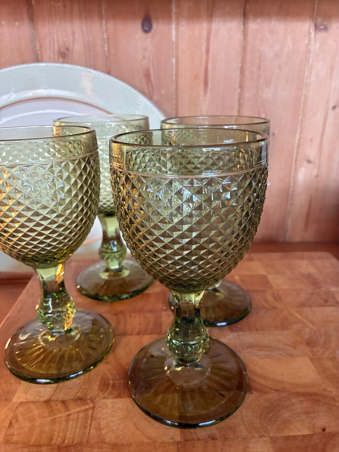 Green Short Stemmed Wine Glass - Set of Four displayed on a wooden table with vintage tableware.
