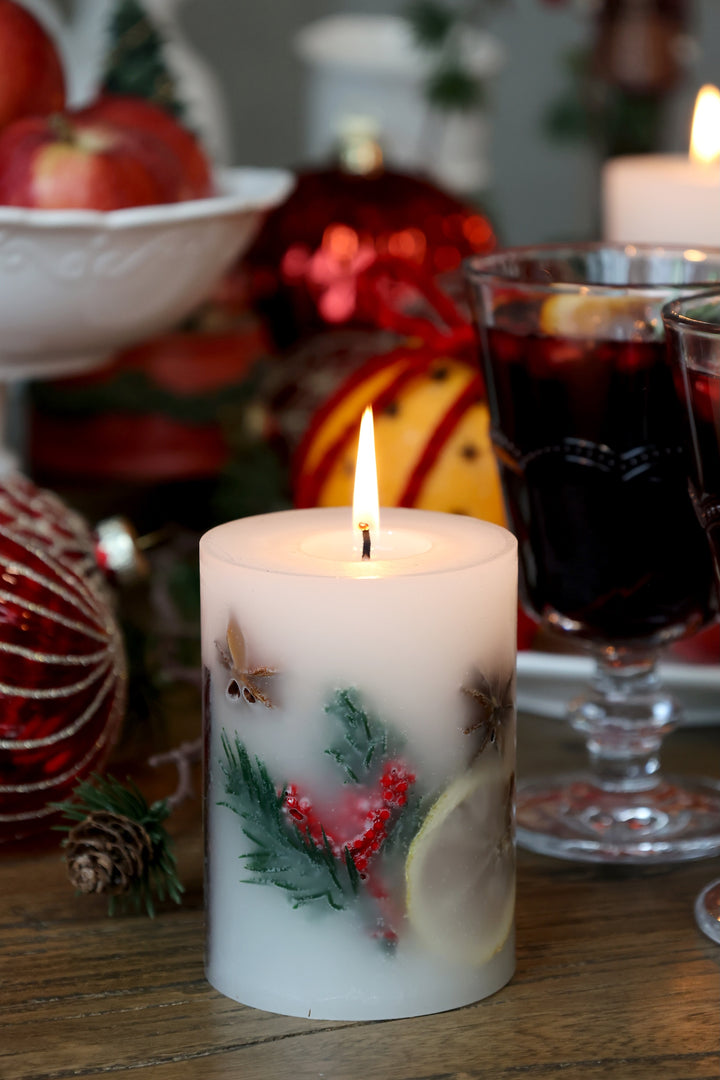 Christmas Spice Pillar Candle from Source for the Goose Devon, featuring festive greenery and warm flickering light.