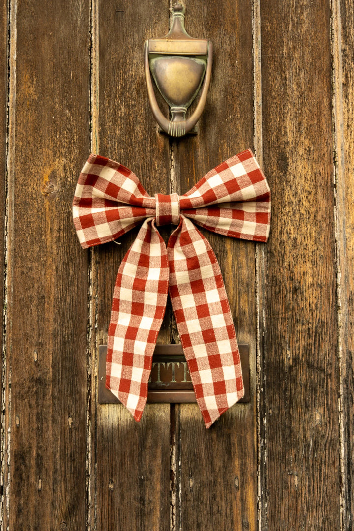 Small Gingham Bow - Two Colours in winter berry color on a rustic wooden door, showcasing vintage style and cottage core charm.