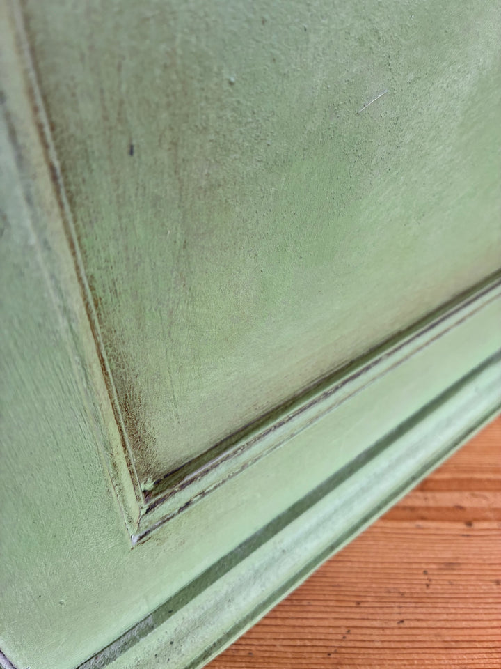 Close-up of the Small Vintage Green Painted Wall Cupboard showcasing its textured green finish and charming detail.