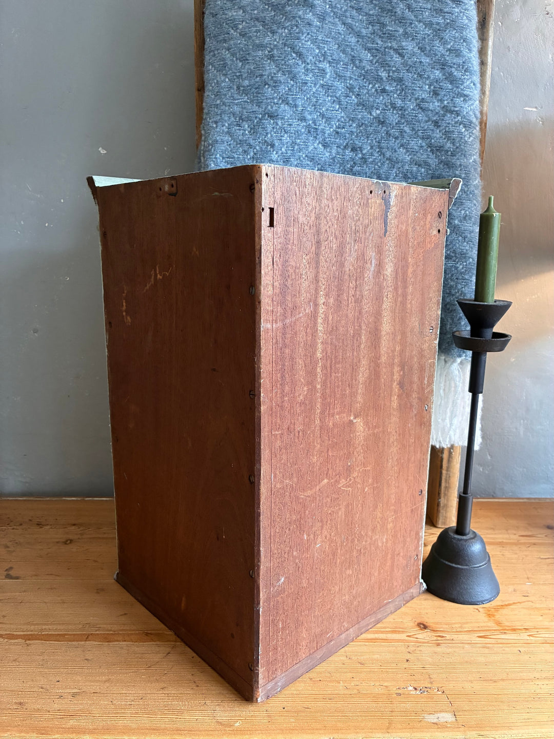 Small Vintage Green Painted Wall Cupboard displayed in a rustic setting with a candle holder and textured fabric.