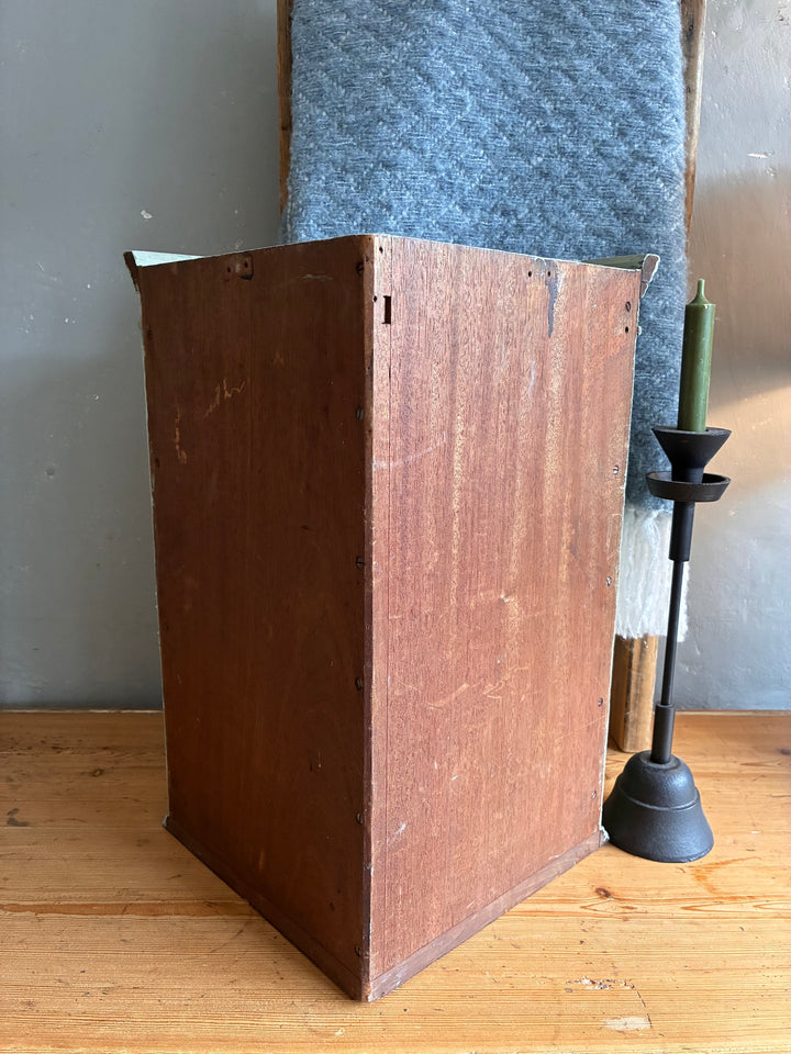 Small Vintage Green Painted Wall Cupboard displayed in a rustic setting with a candle holder and textured fabric.