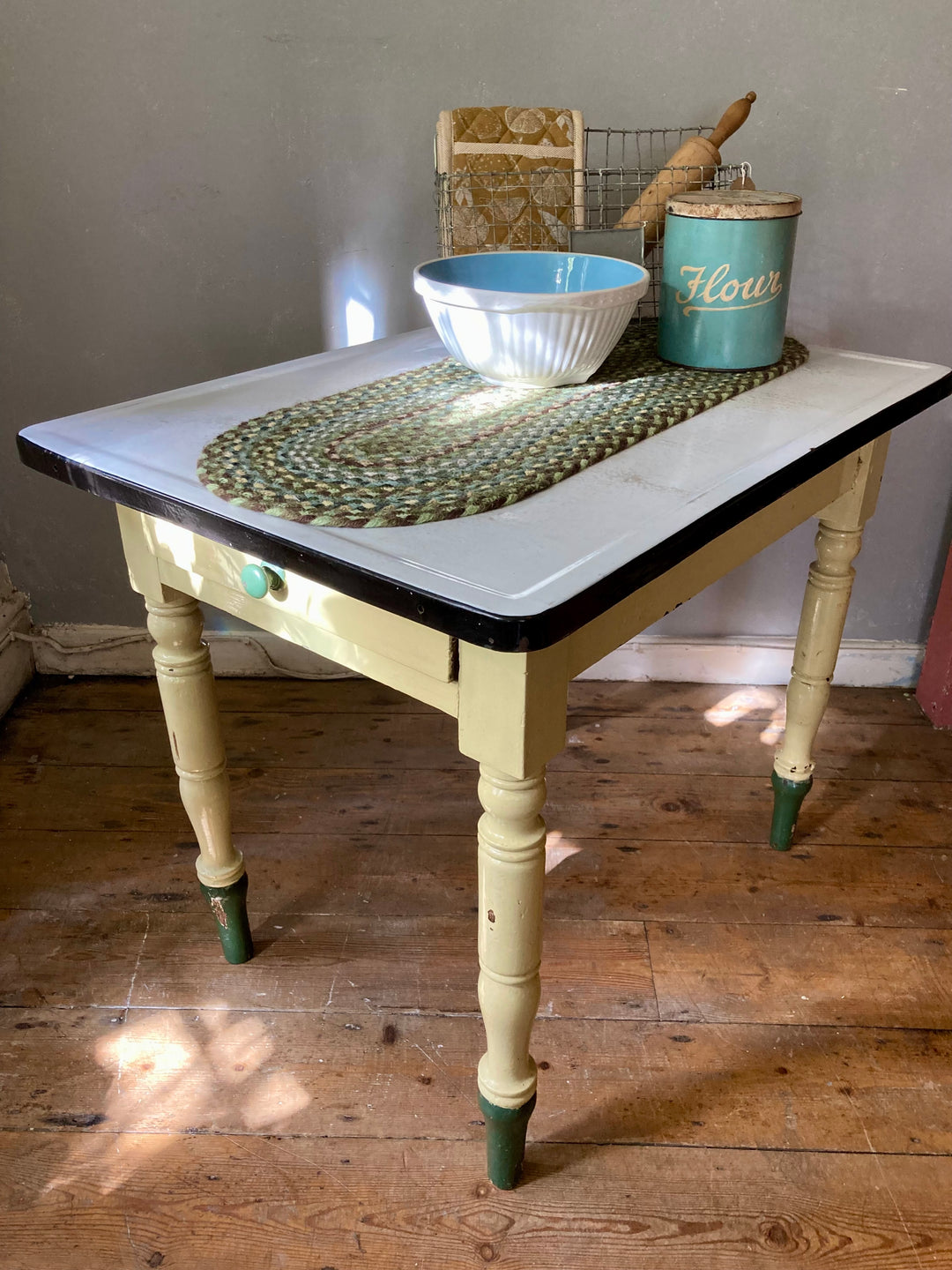 Small vintage enamel top table with drawer, featuring cream and green paintwork, ideal for farmhouse kitchens. Source for the Goose Devon.