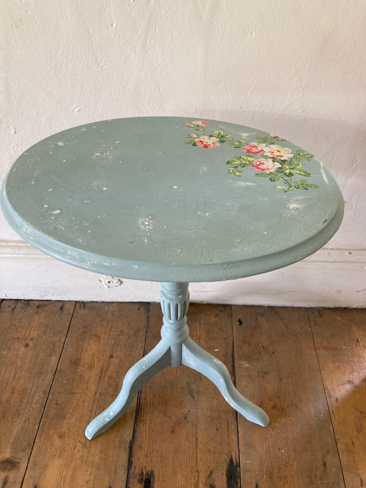 oval topped table with rose design on blue background