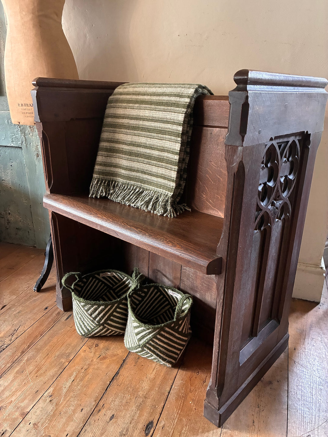 Small Antique Church Pew with a blanket and woven baskets in a cozy interior setting.
