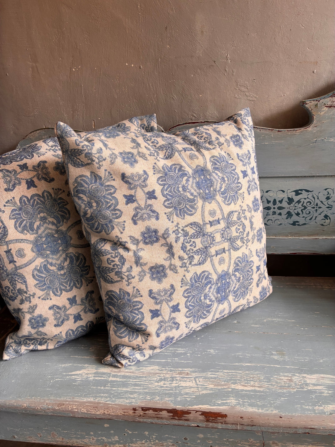 Softspell Wedgewood Blue Linen Mix Cushion on a rustic blue bench with floral pattern.