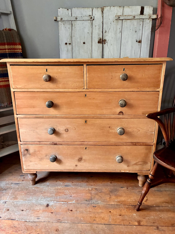 Tall Rustic Antique Pine Chest of Drawers with two top drawers and three larger drawers, original knobs, and turned feet