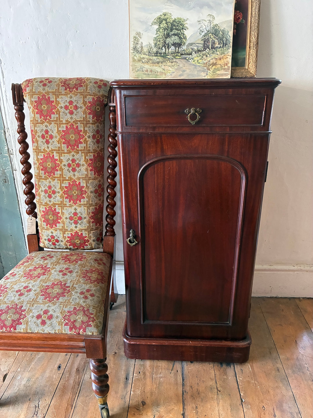 Tall Victorian Mahogany Pot Cupboard beside a patterned chair, showcasing rich details and antique charm.