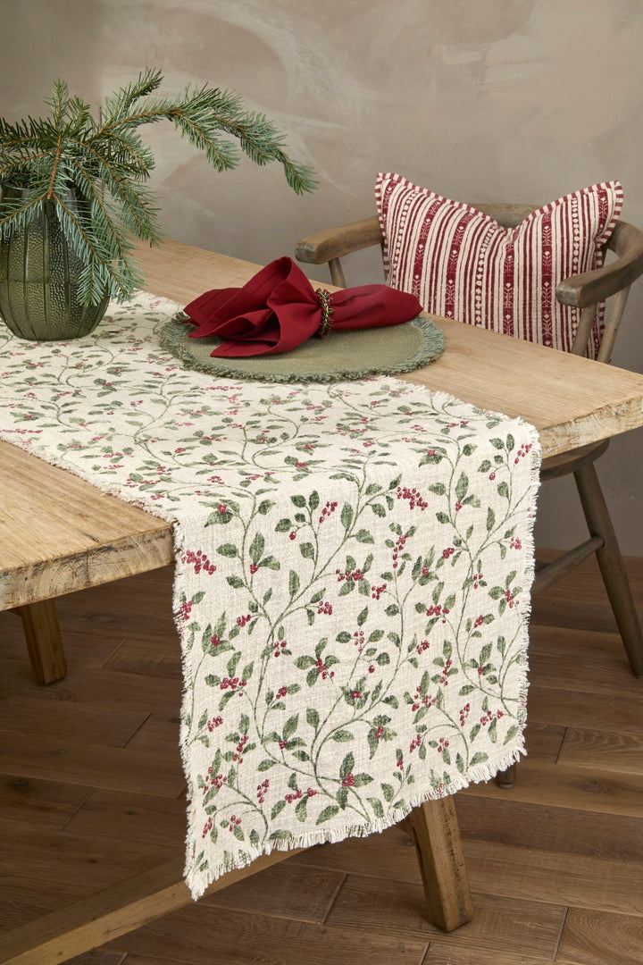 Trailing Berry Christmas Table Runner - Slub Cotton displayed on a wooden table with festive decor.