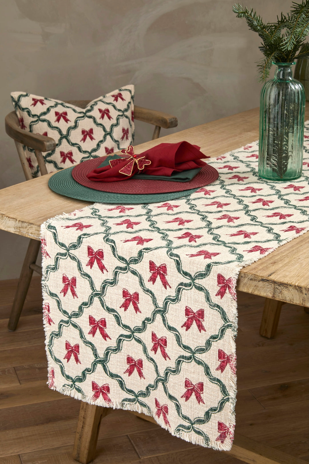 Woven Soft Green Circular Placemat on a rustic table with red bows decor and green tableware accents.