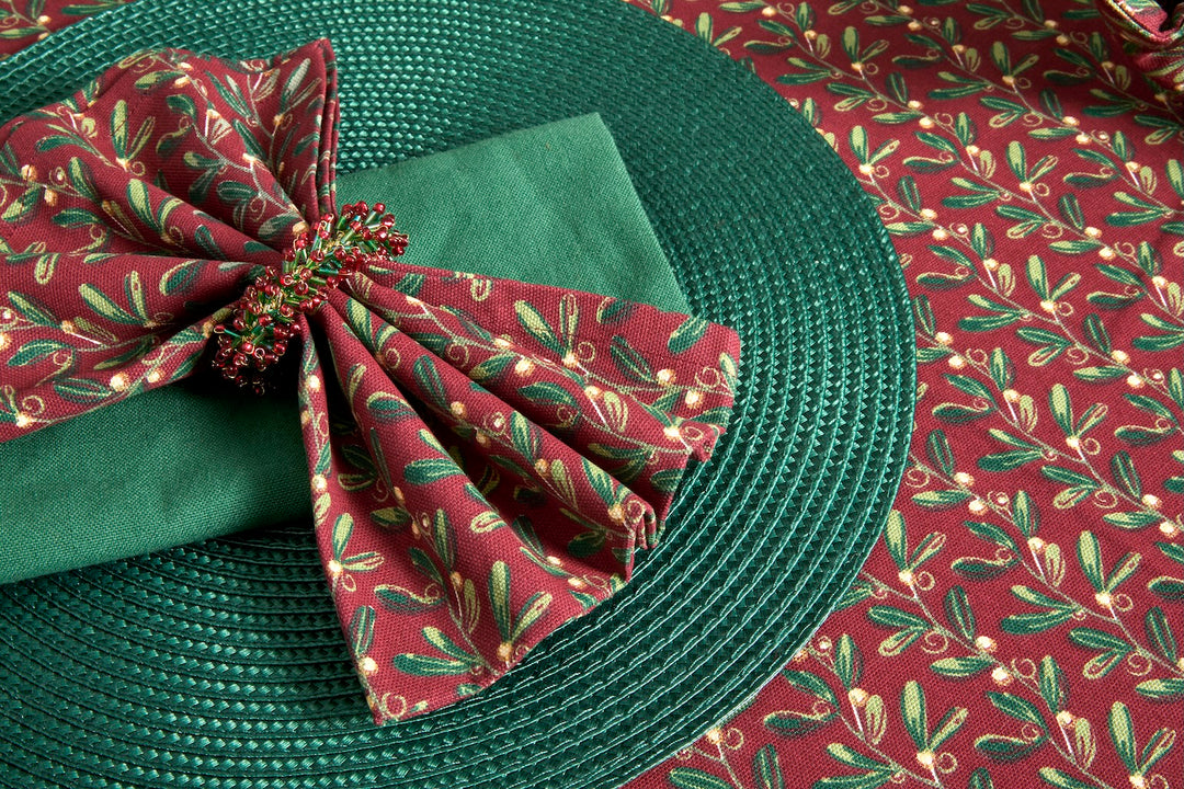 Under The Mistletoe Napkin - Set of Four on a festive table setting with green placemat and seasonal decor.