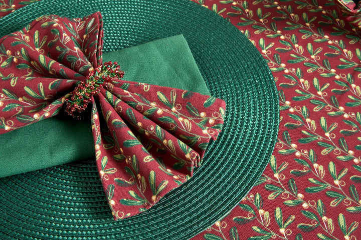 Under The Mistletoe Napkin - Set of Four on a festive table setting with green placemat and seasonal decor.