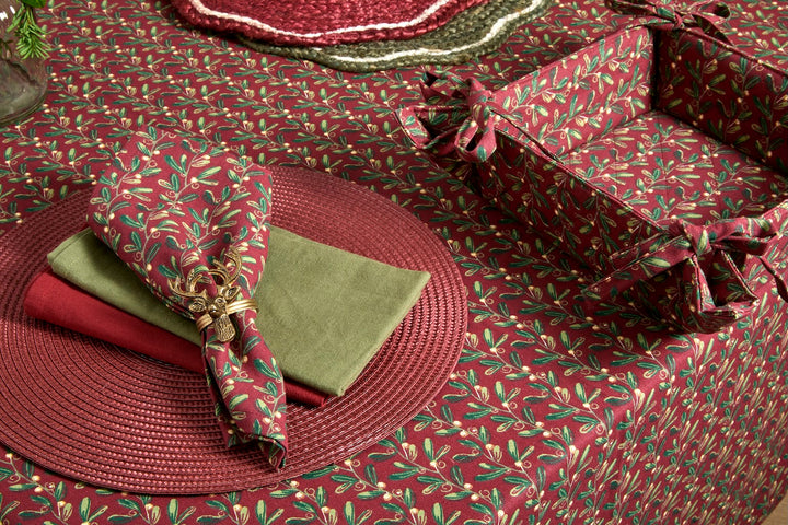 Under The Mistletoe Napkin - Set of Four displayed on a festive red table setting.