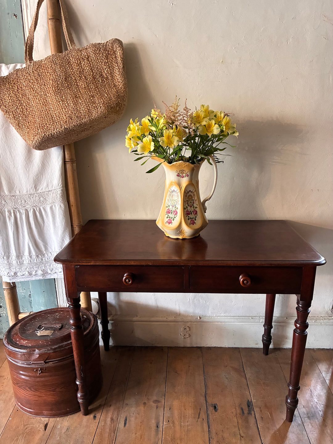 Victorian mahogany console table with floral arrangement and decorative pitcher, perfect for hallway decor.