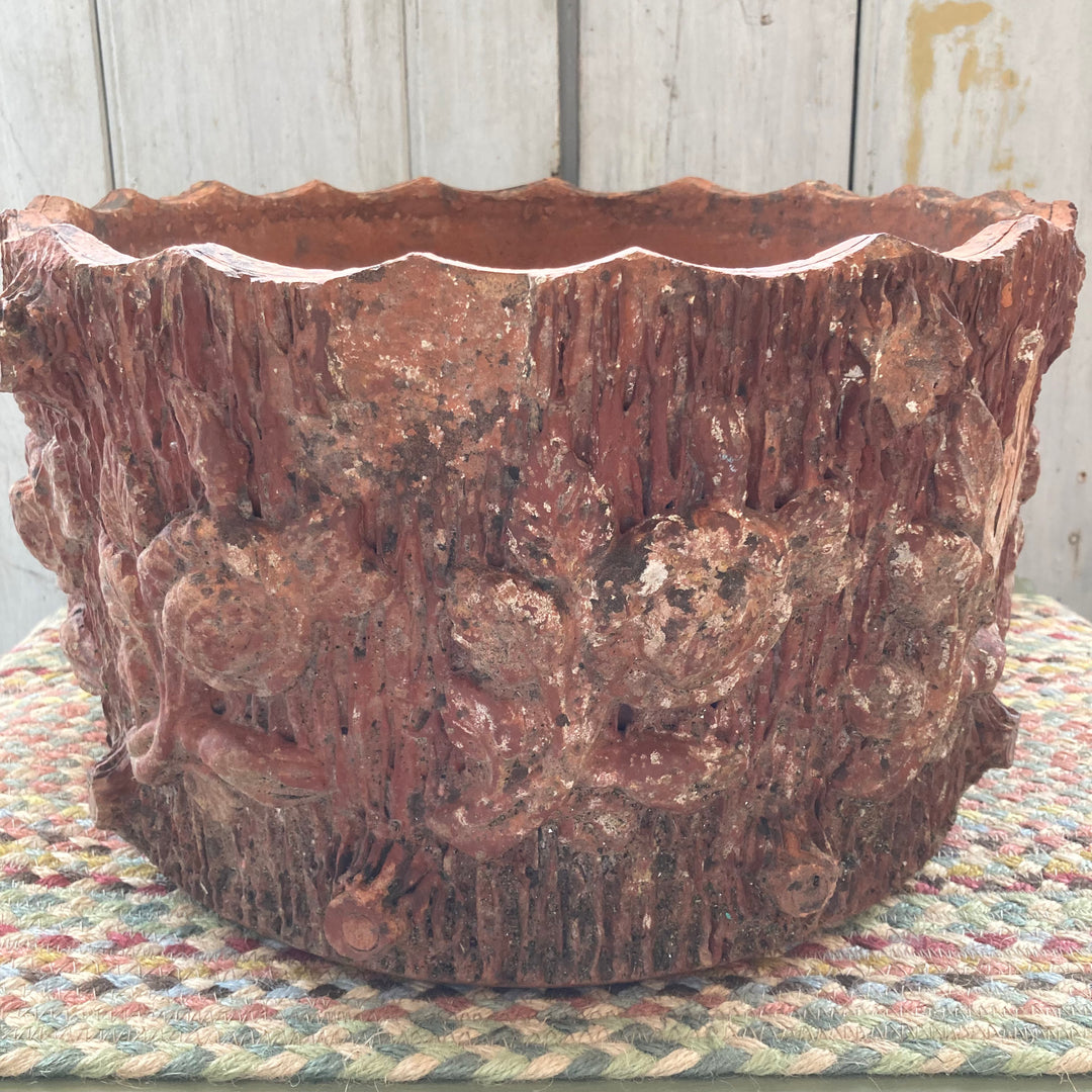 age related damage to leaf and flower design on old terracotta planter
