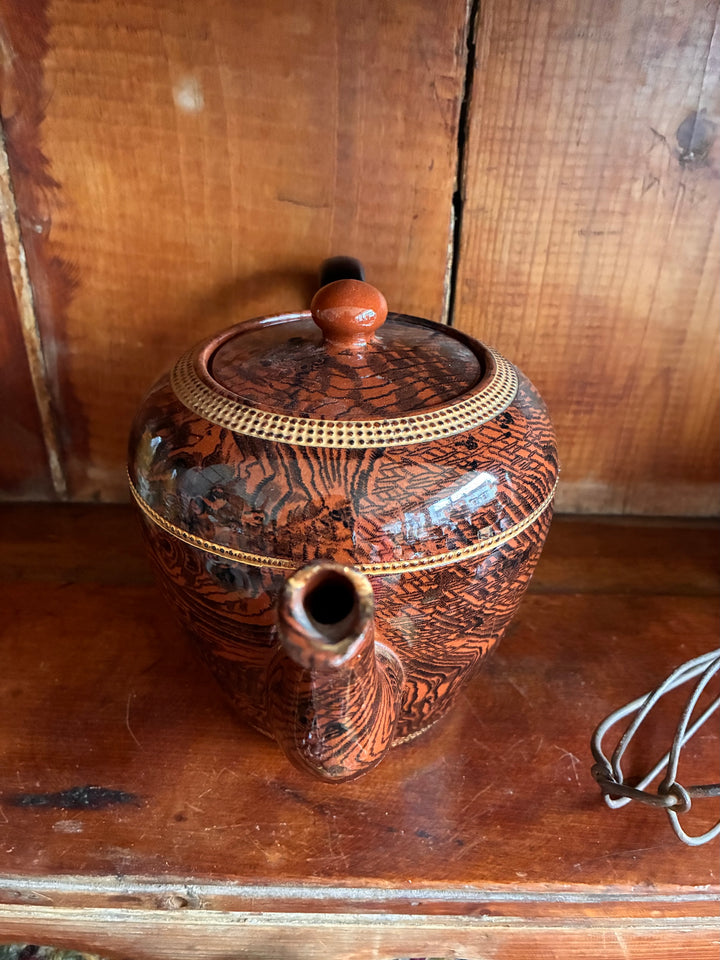 Vintage Oak Ware Design Brown Betty Teapot with bark-like pattern and gilt stripes on wooden table.