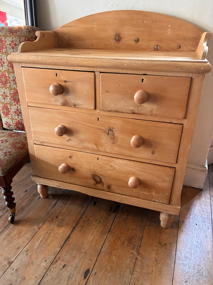 Small Antique Pine Chest of Drawers - Galleried Back displayed in rustic interior setting.