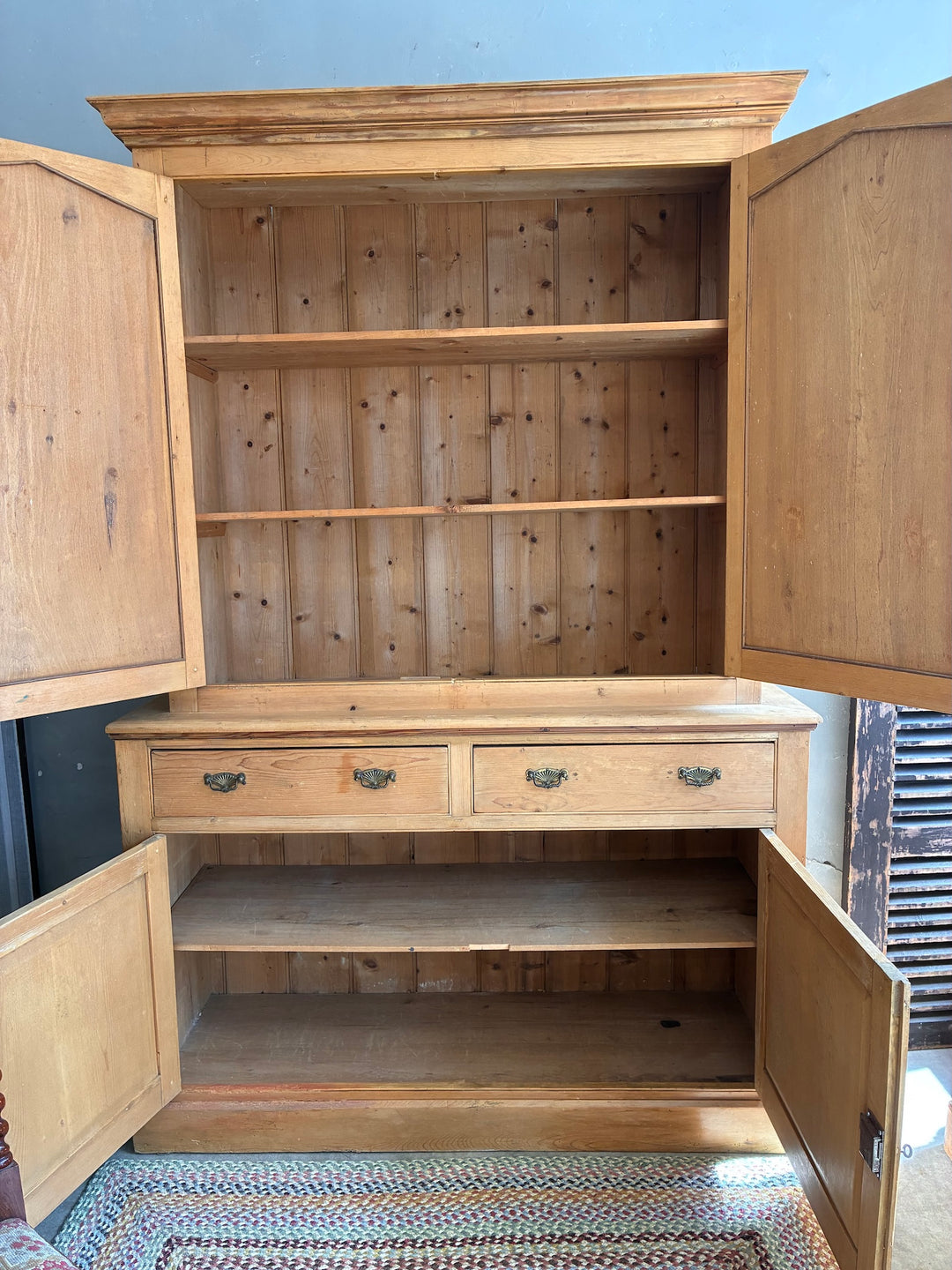 Victorian Pine Housekeepers Cupboard showcasing open doors, shelves, and drawers for ample storage.