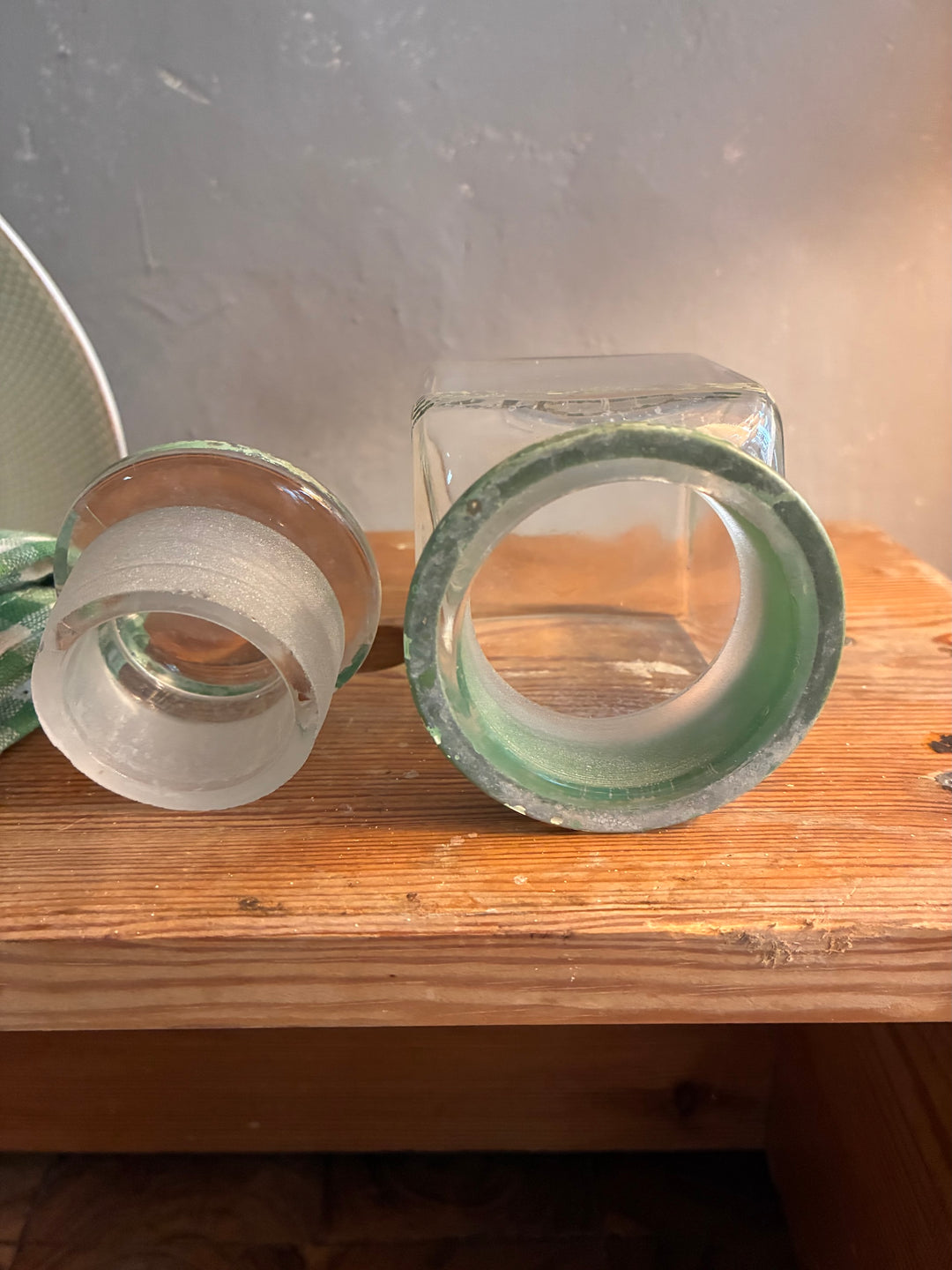 Vintage 1930s Glass Bathroom Set featuring three authentic glass bottles with green lettering and stoppers.
