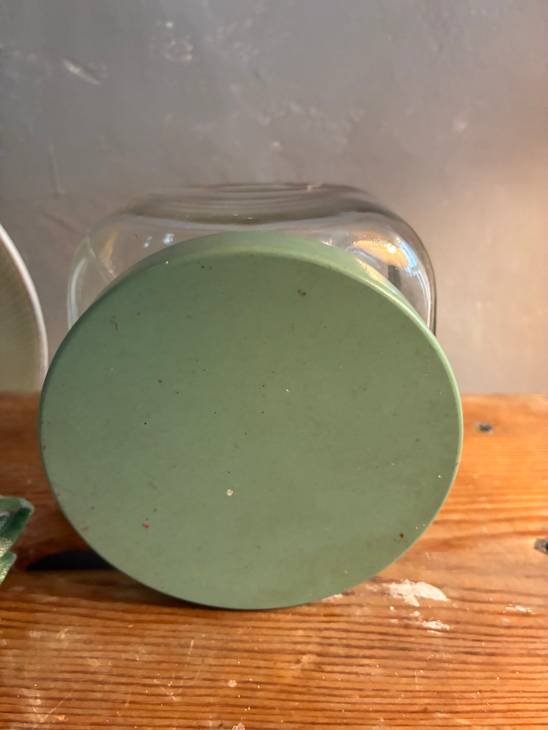 Vintage 1930s Glass Bathroom Set base view showcasing green stopper on a wooden surface.