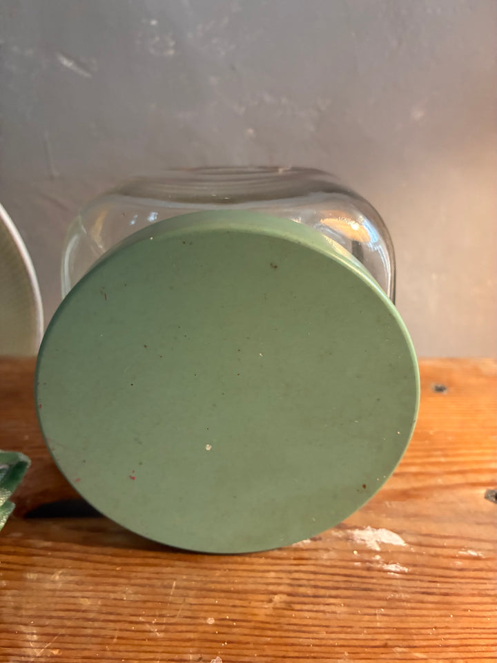 Vintage 1930s Glass Bathroom Set base view showcasing green stopper on a wooden surface.