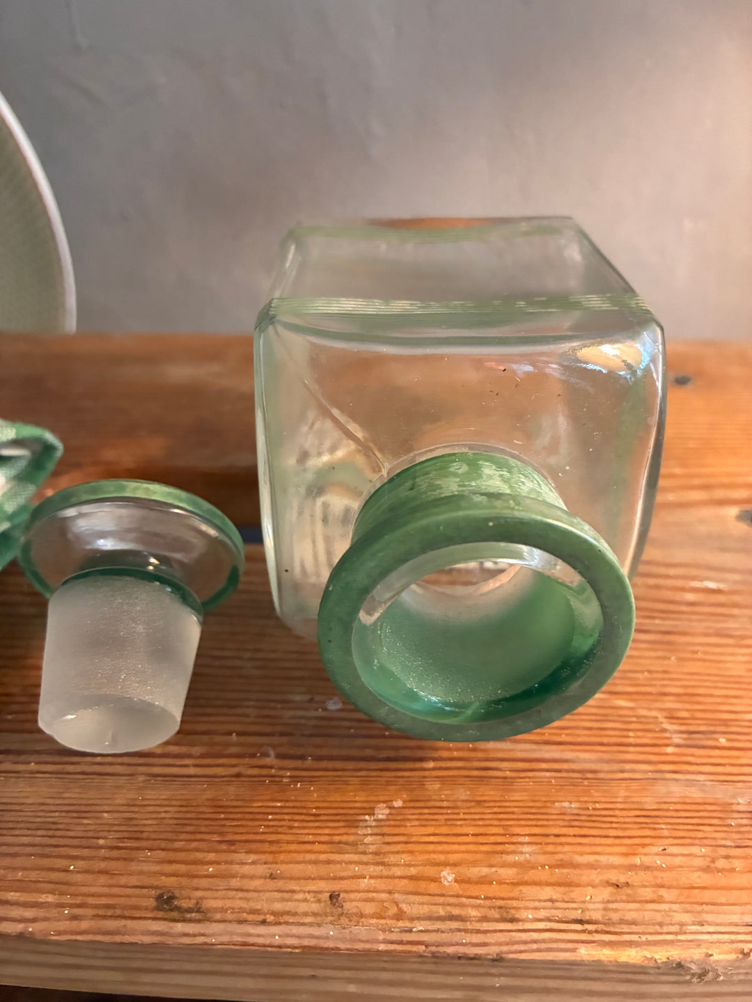 Vintage 1930s Glass Bathroom Set featuring green glass bottles and stoppers, showcasing authentic vintage character.