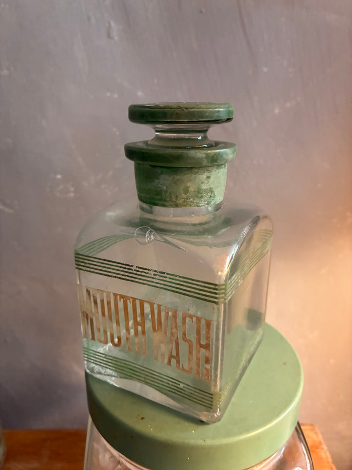 Vintage 1930s Glass Bathroom Set Mouth Wash bottle with green lettering and glass stopper.