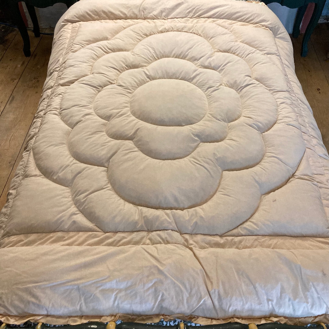 Vintage 1930s Single Eiderdown in creamy apricot gold satin on a bed.