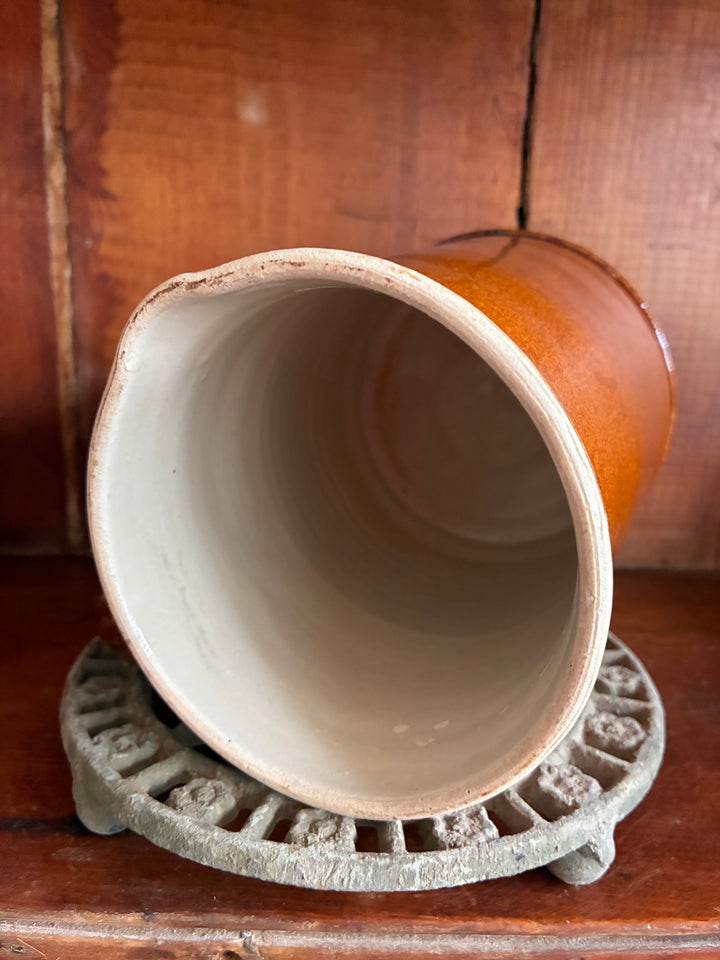 Antique French Earthenware Milk Pitcher showcasing rustic glaze and smooth interior on a decorative coaster.
