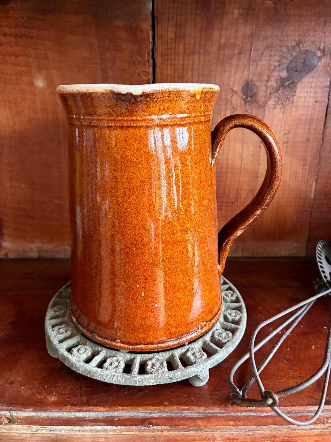 Antique French Earthenware Milk Pitcher with rustic brown glaze on vintage metal base.