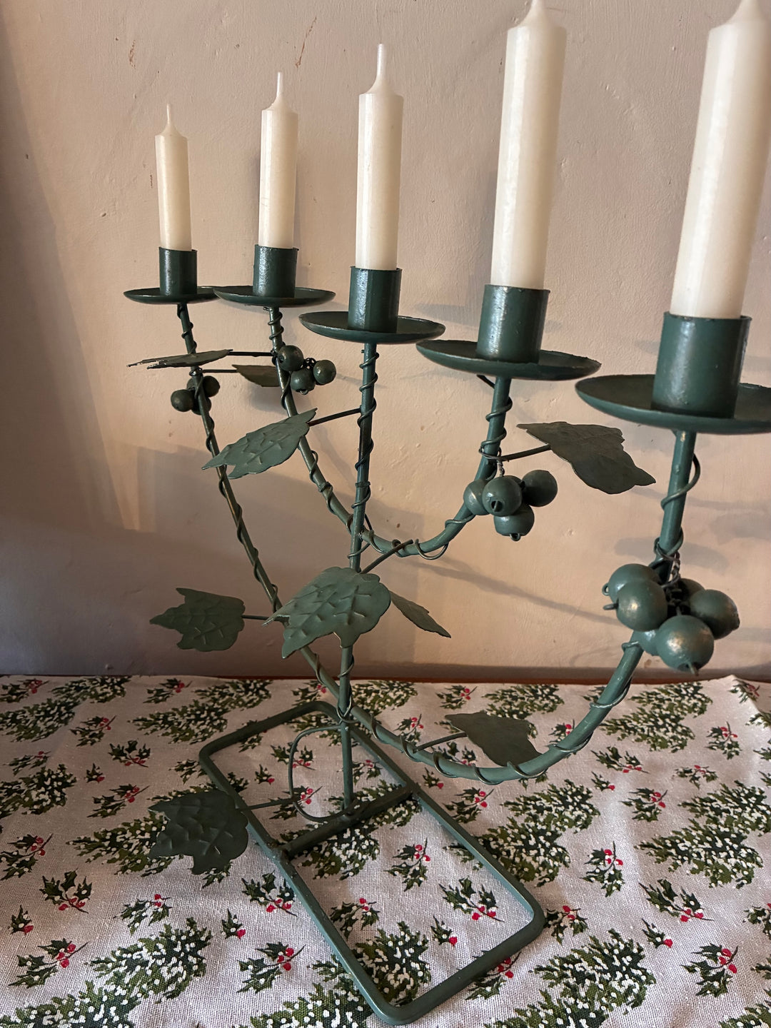 Vintage Green Five Arm Candelabra decorated with metal vines and grapes on a floral tablecloth.