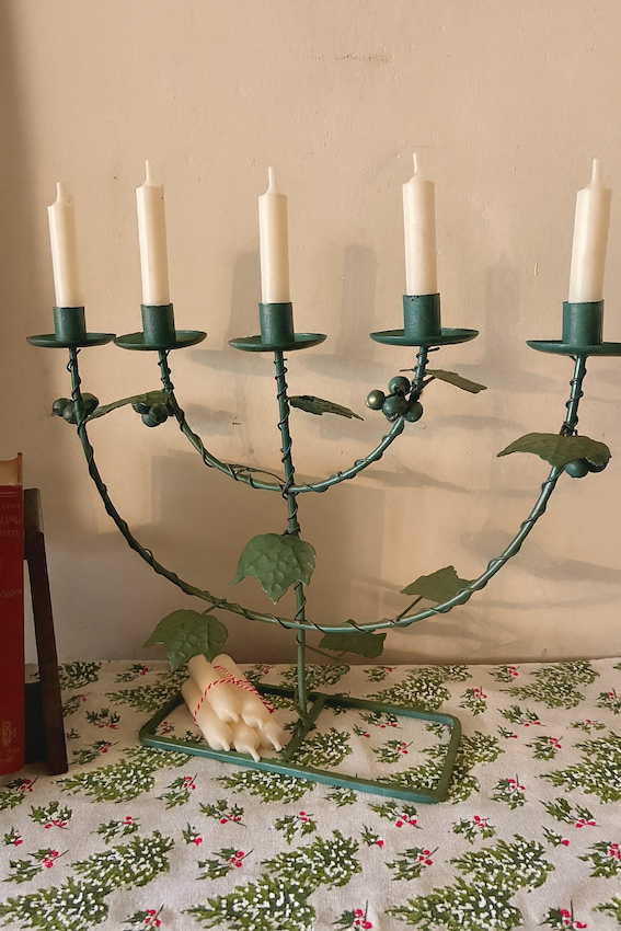 Vintage Green Five Arm Candelabra on a table with white candles and green vine details.