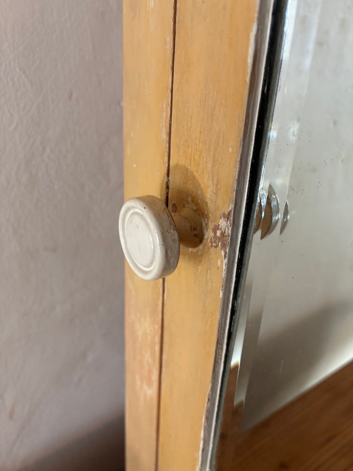 Close-up of cream bakelite handle on a Vintage Mirrored Bathroom Cabinet, showcasing vintage charm and craftsmanship.