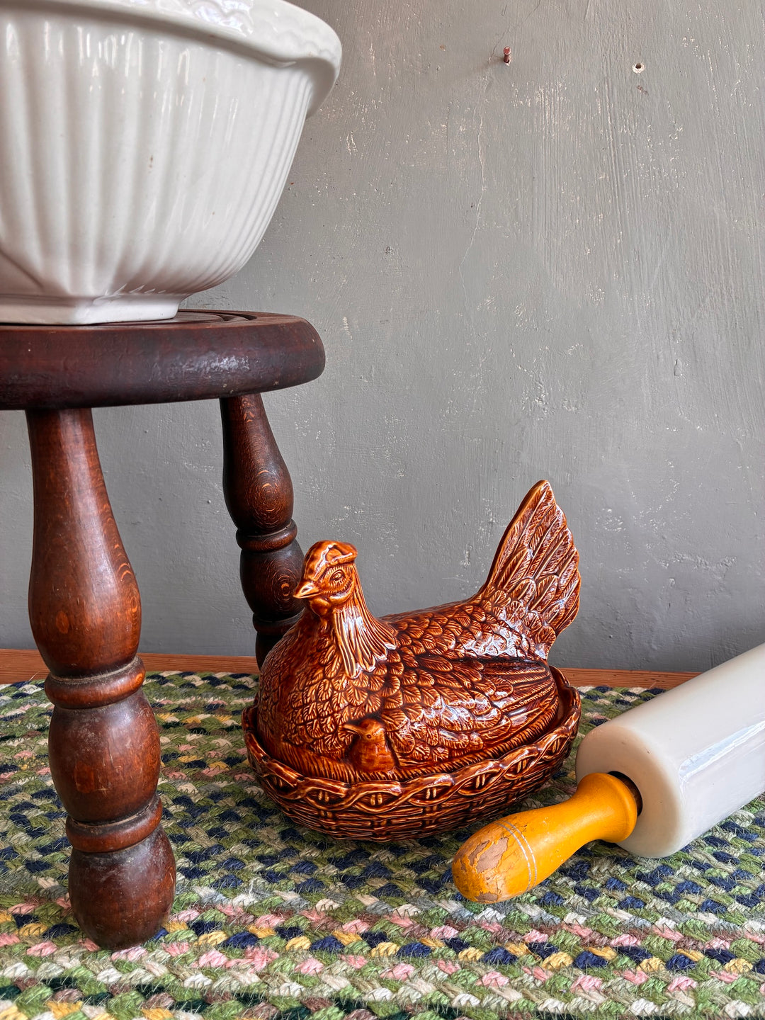 Vintage Portmeirion nesting hen egg holder in brown glaze beside a rolling pin, perfect for country-style kitchens.