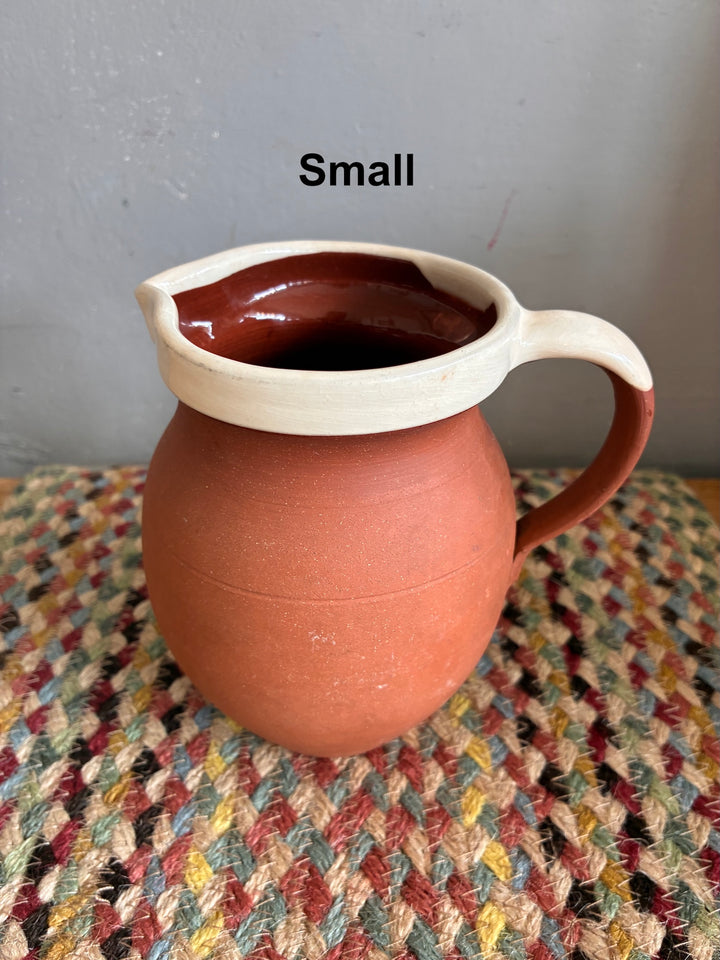 Vintage Slipware Terracotta Jug - North Devon showcased, small size with cream slipware rim on woven background.