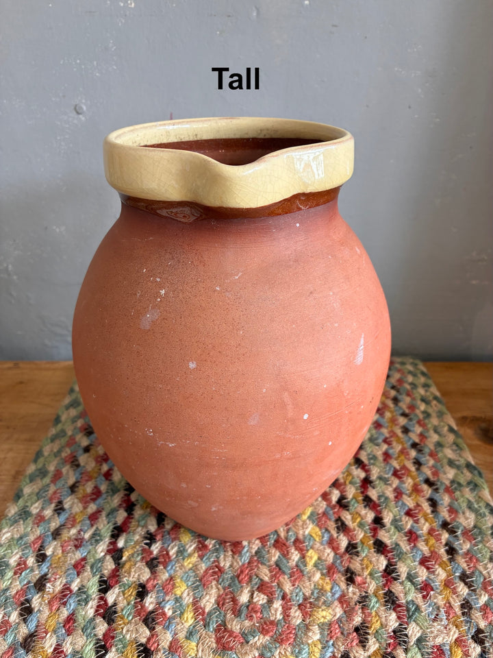 Vintage Slipware Terracotta Jug - North Devon, tall terracotta jug with cream slipware rim on textured surface.
